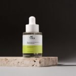 A 30ml dropper bottle of Vita Elixia Bioactive Prebiotics Jelly Serum placed on a textured stone pedestal against a dark, minimalist background