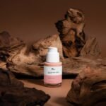A bottle of Vita Elixia Peptide Anti-Aging Serum displayed elegantly among rustic driftwood pieces, highlighting natural skincare products