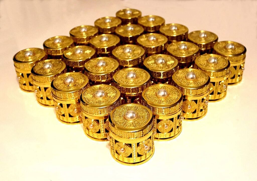 A collection of small, ornate gold-embossed cylindrical gift jars with pearl accents on the lids and sides, arranged in a large grid pattern