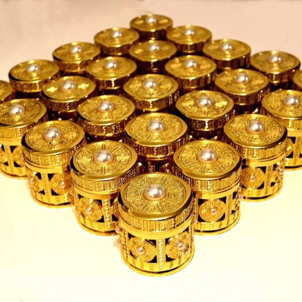 A collection of small, ornate gold-embossed cylindrical gift jars with pearl accents on the lids and sides, arranged in a large grid pattern