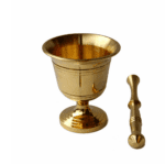 A polished, traditional golden brass mortar and pestle set for grinding organic spices and herbs, isolated against a clean white background.