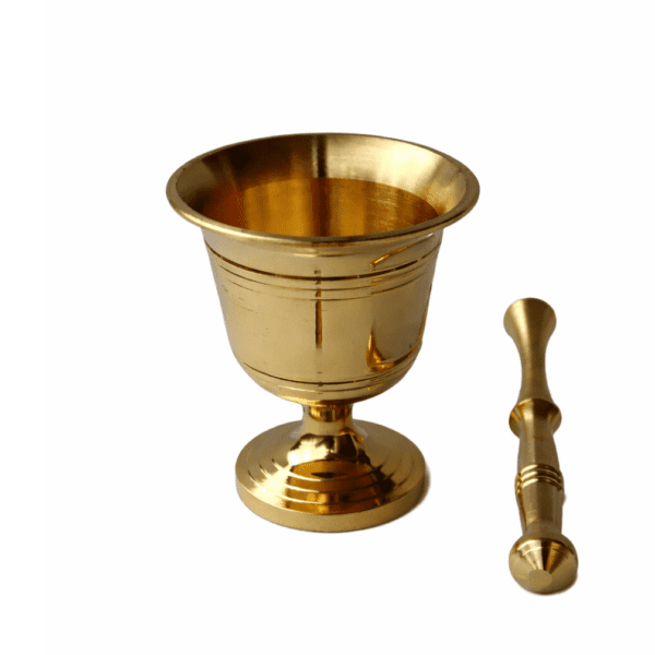 A polished, traditional golden brass mortar and pestle set for grinding organic spices and herbs, isolated against a clean white background.