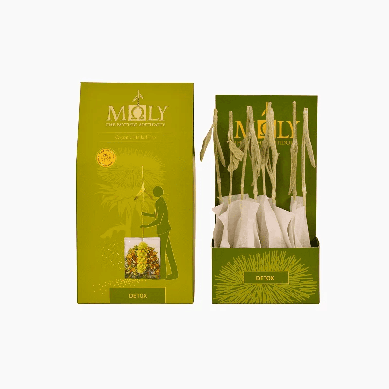 Lime green retail box for Moly "Detox" Organic Herbal Tea shown alongside an open display box filled with individually wrapped tea bags featuring natural herbal stem stirrers.