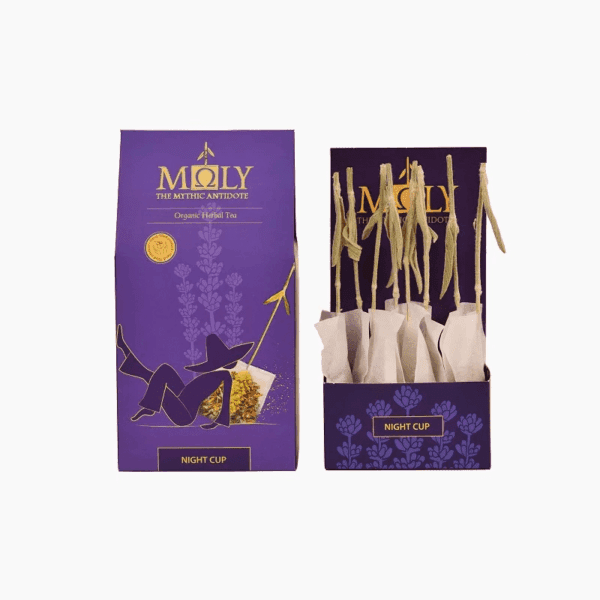 Deep purple retail box for Moly "Night Cup" Organic Herbal Tea shown next to an open display box containing individually wrapped tea bags with natural herbal stem stirrers.