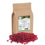 A 500g brown kraft paper stand-up pouch of Blumental Bayern Bio-Berberitzen, shown behind a pile of vibrant, whole dried red barberries
