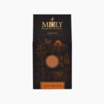 Black Moly Organic Herbs Carob with herbs packaging featuring gold botanical line art and a circular window showing a fine brown powder
